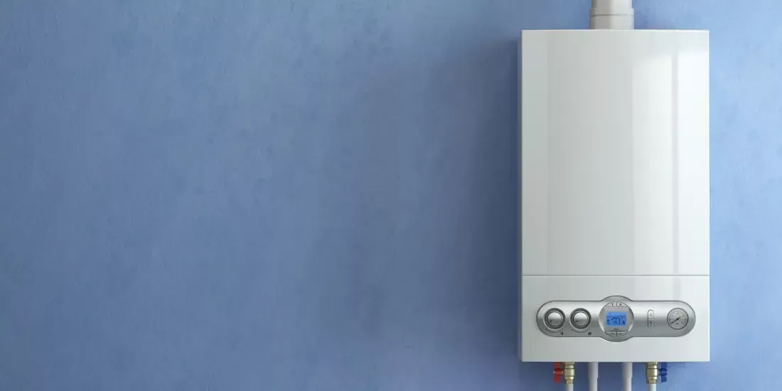 A white wall mounted boiler on a blue wall