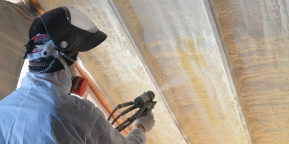 Spray foam installer working in loft cavity