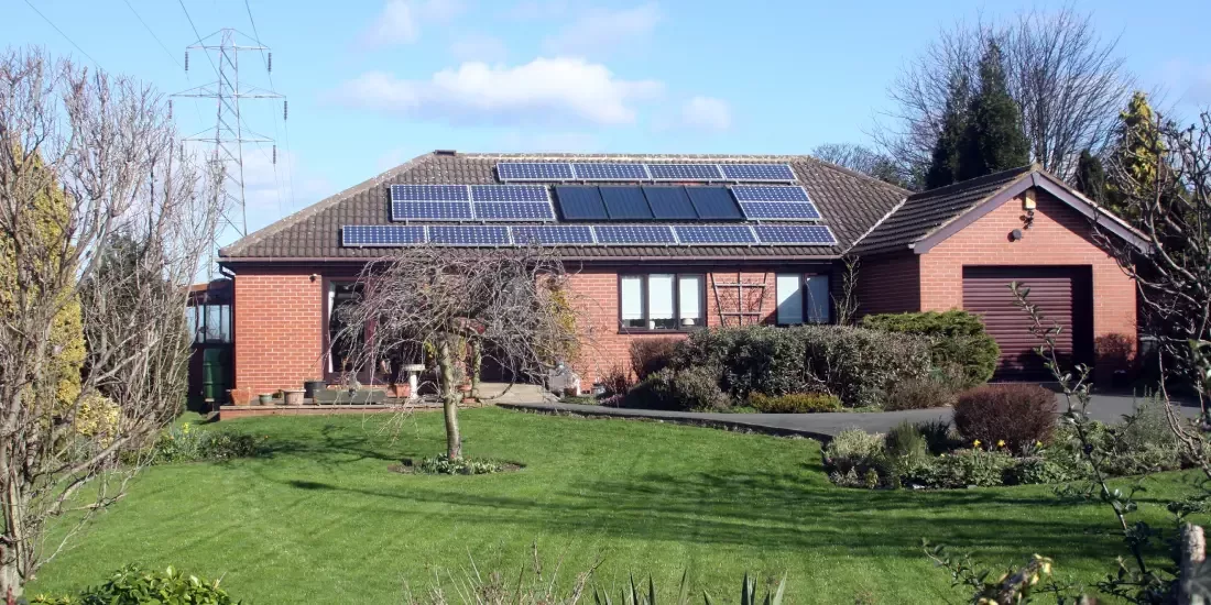 A bungalow with solar panels and solar heating installed