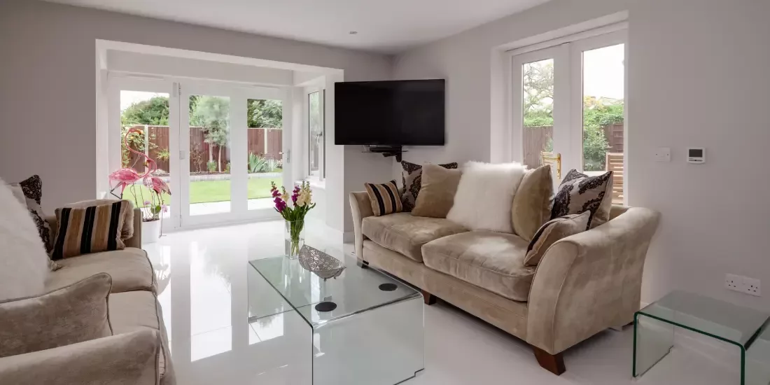 A modern new build lounge with a white bifold door and casement door