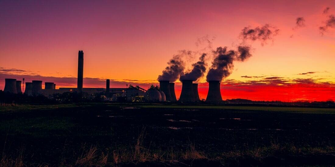 Silhouette of a power station at sunset