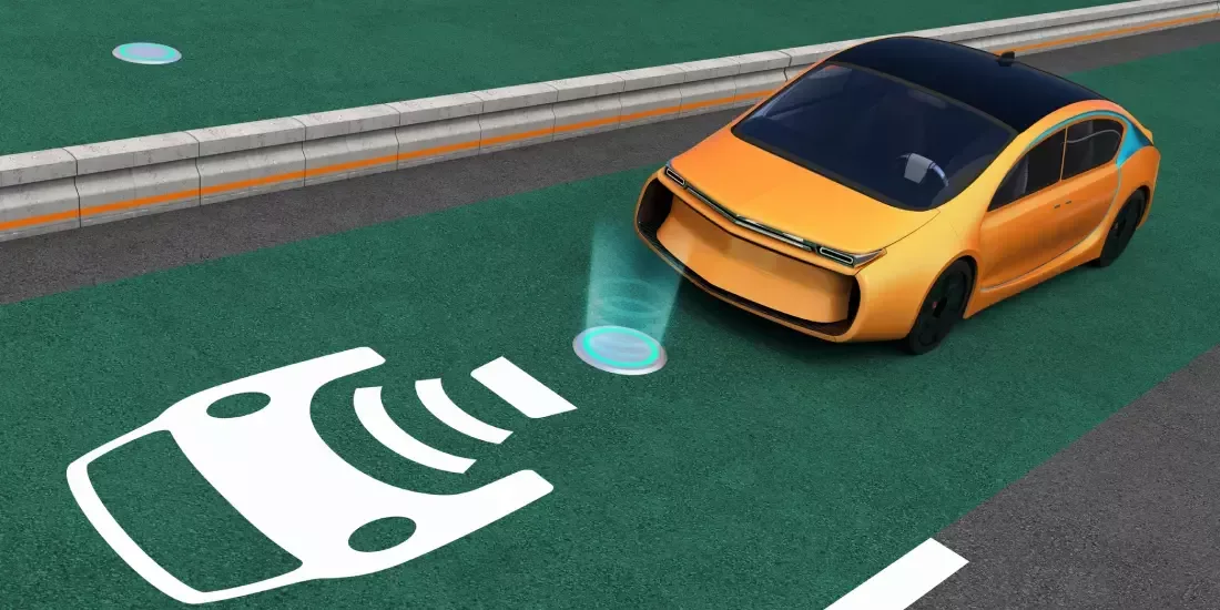 CGI of an orange EV driving across a green lane on the motorway featuring wireless charging